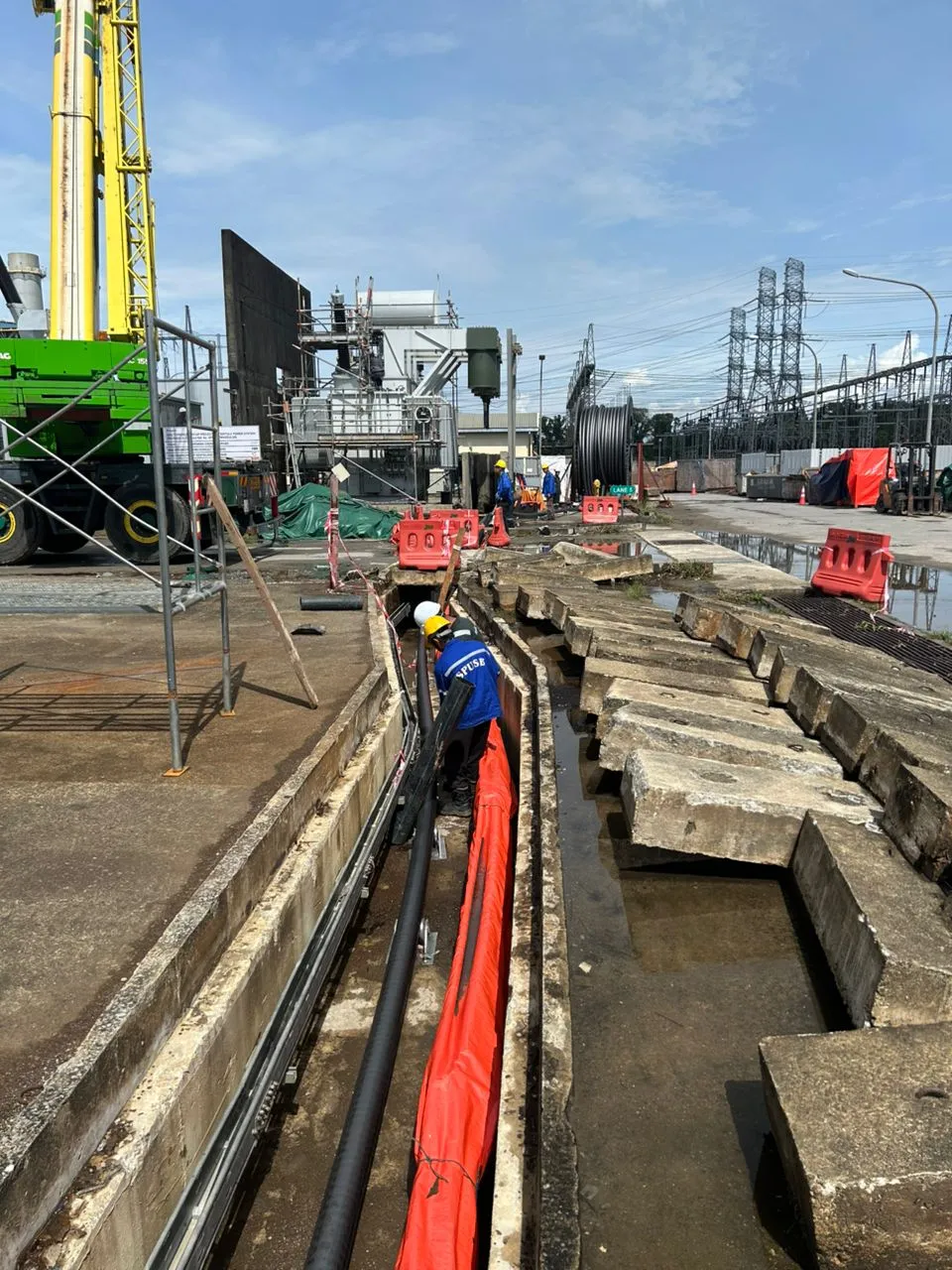 High-voltage power cables being laid in a trench at a power station.