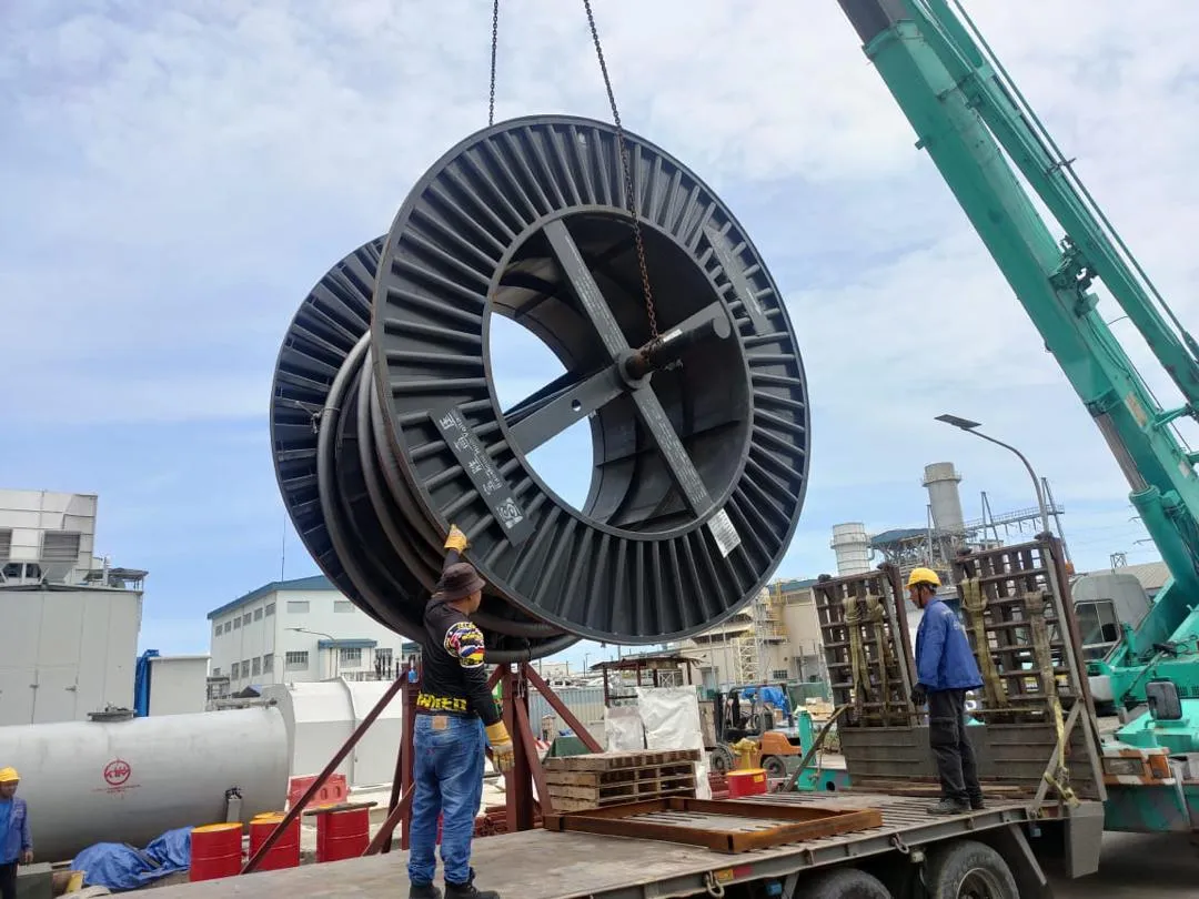 A large extra-high-voltage component being lifted into position by crane.