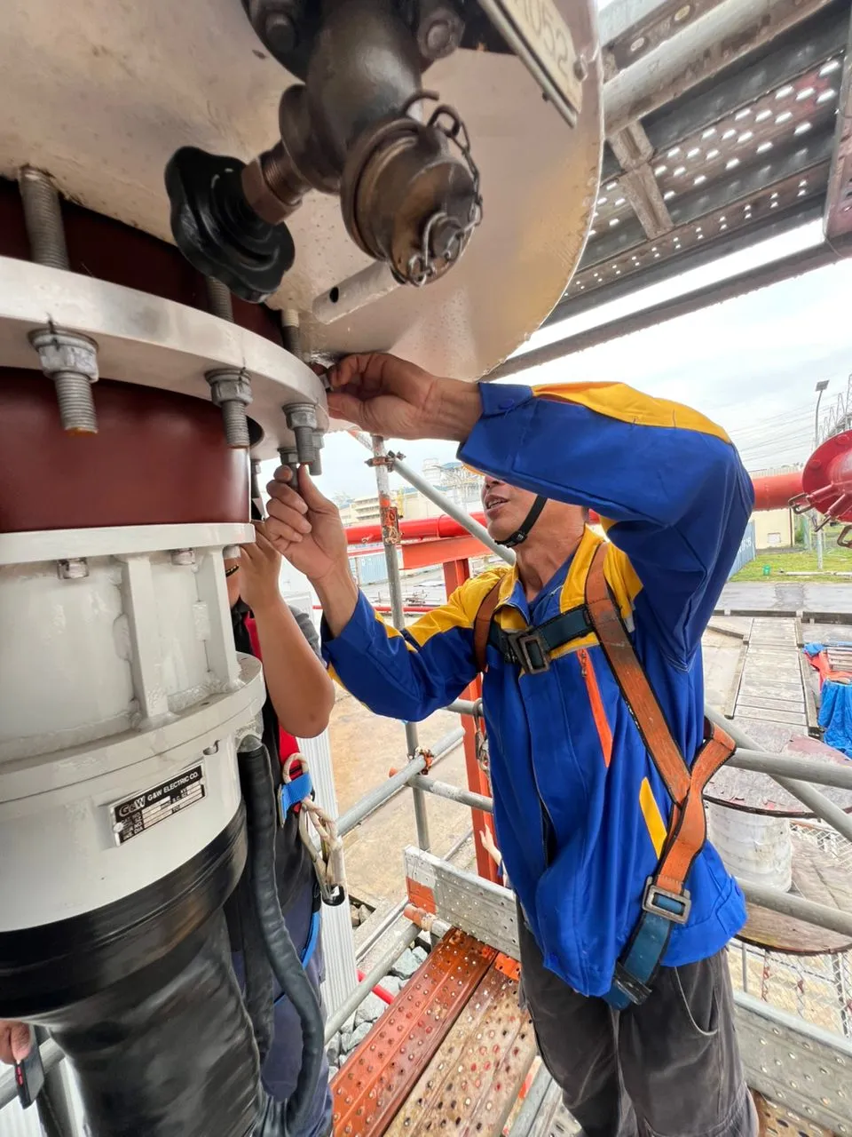 A high-voltage cable termination being assembled on a transformer bushing.