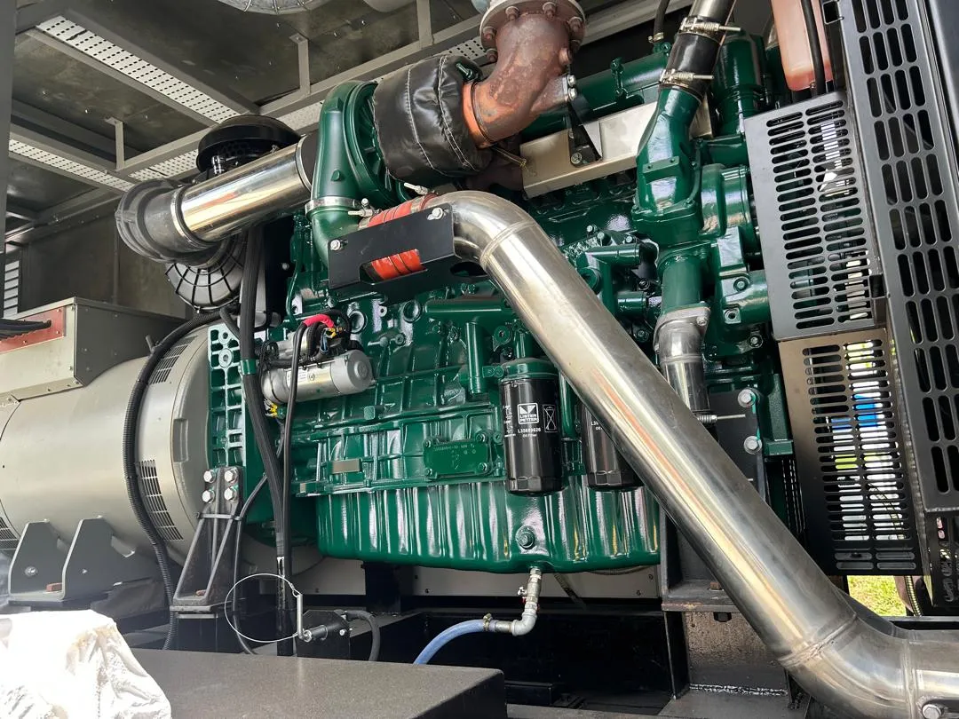 A diesel generator set engine and alternator inside its canopy.