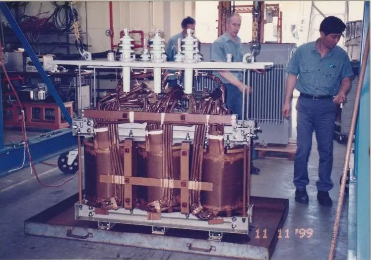 A three-phase dry-type transformer under construction in the workshop.