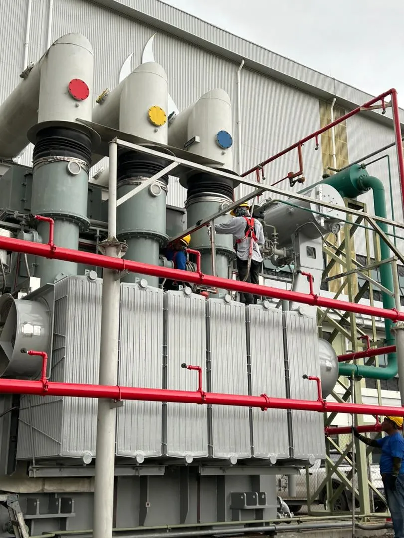 A large power transformer with bushings and pipework at a Sarawak power station.