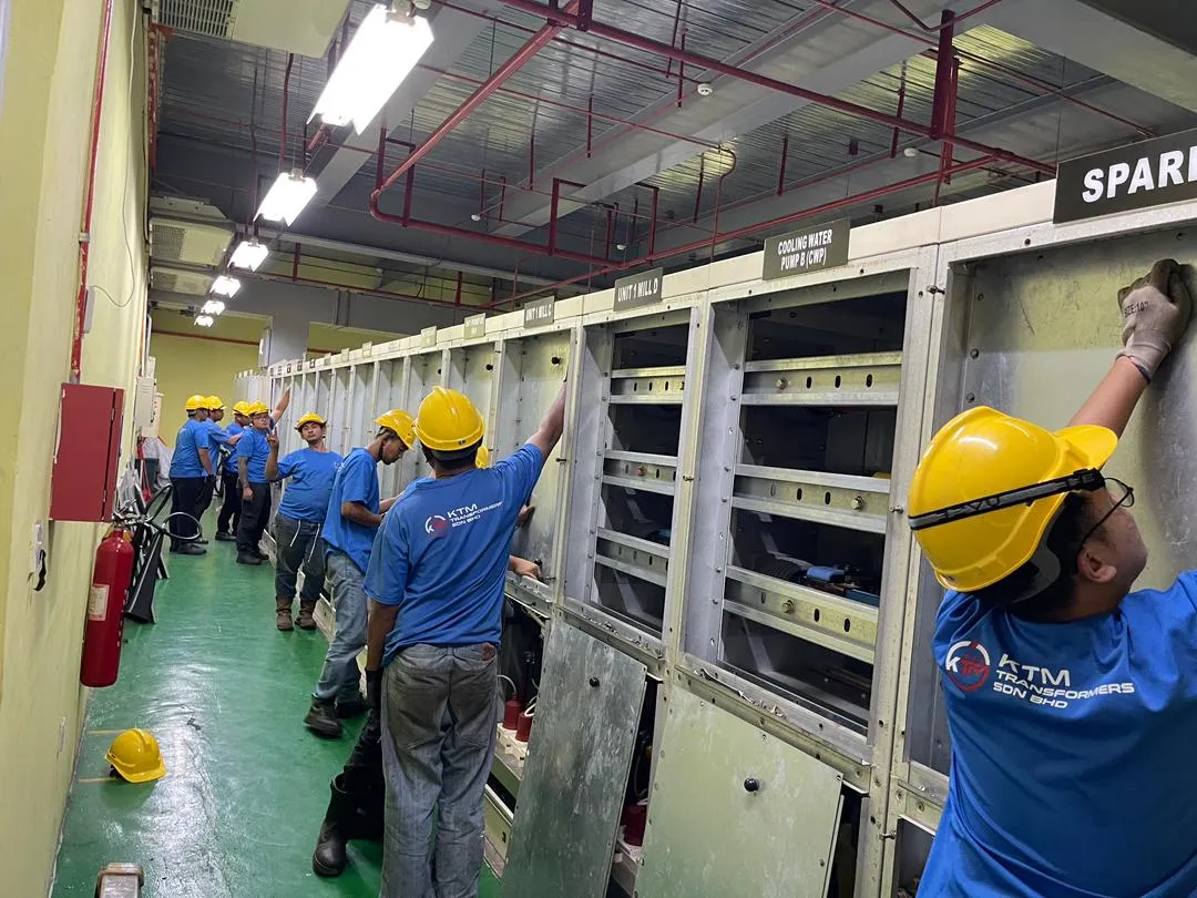 KTM Transformers technicians maintaining a switchgear line-up at an industrial plant.