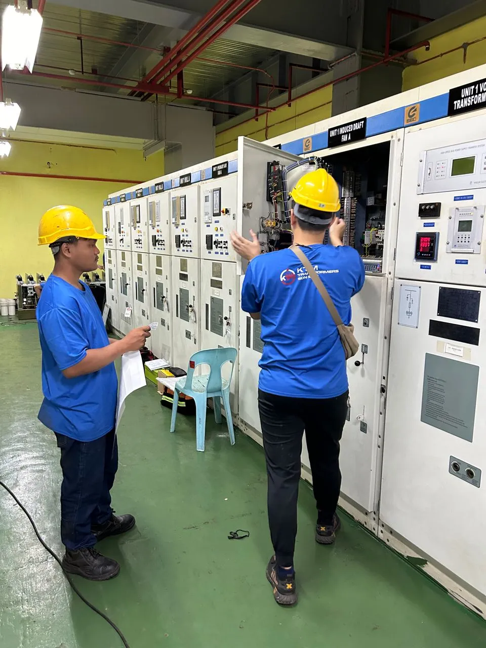 A technician working inside a switchgear panel.